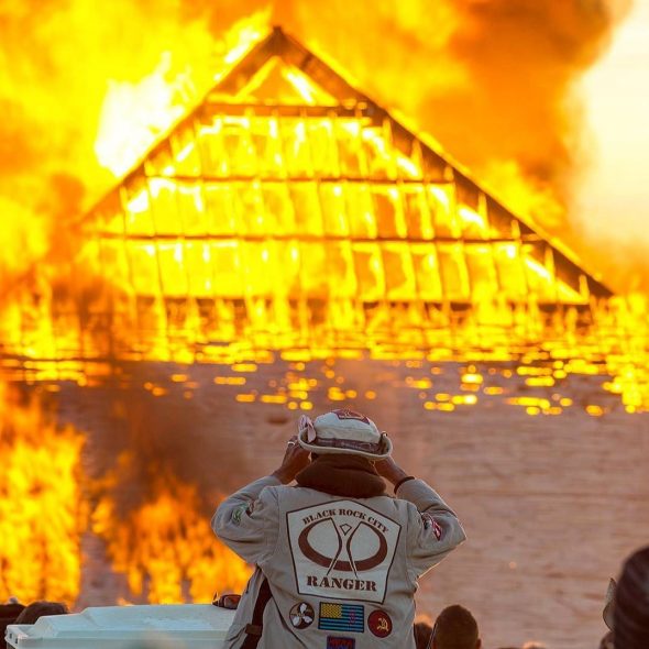 Catacomb of Veils pyramid set ablaze while a BRC ranger looks on.